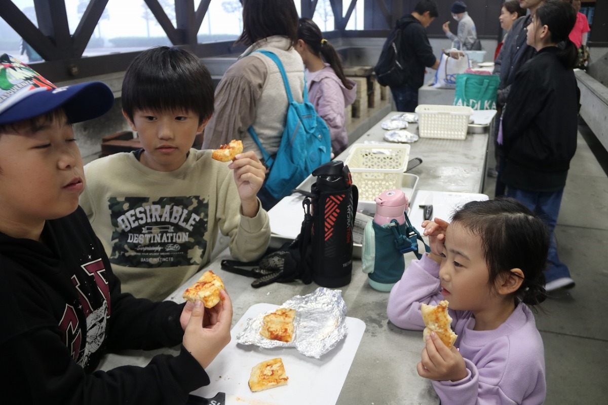 美味しそうにピザを食べる様子です。